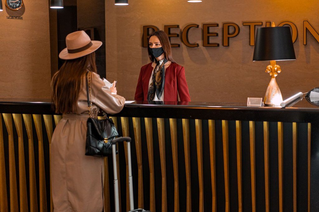 Woman at reception booking hotel room